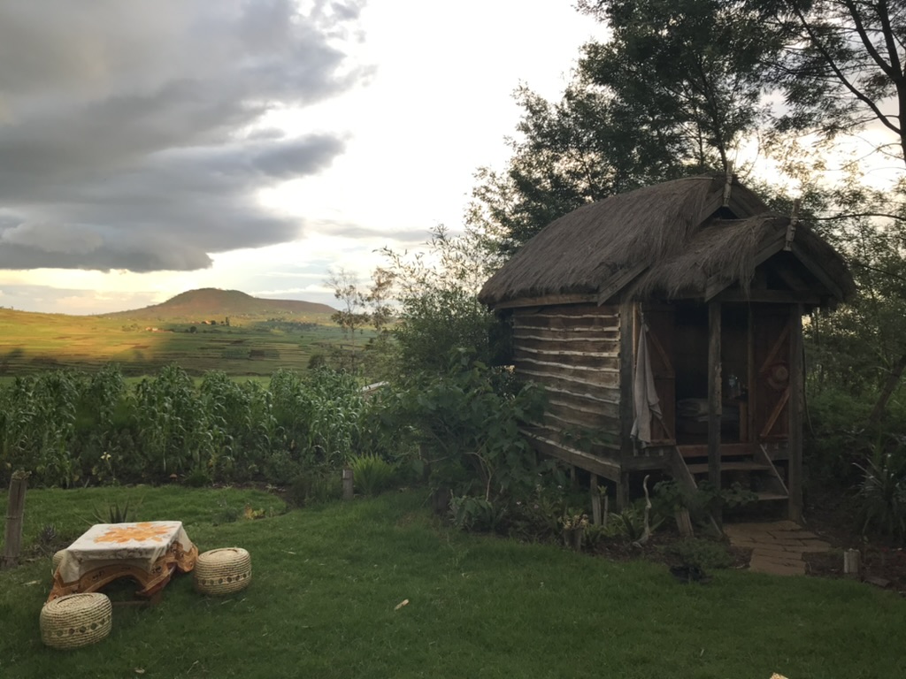 a small hut for sleeping and a view of the green valley behind it